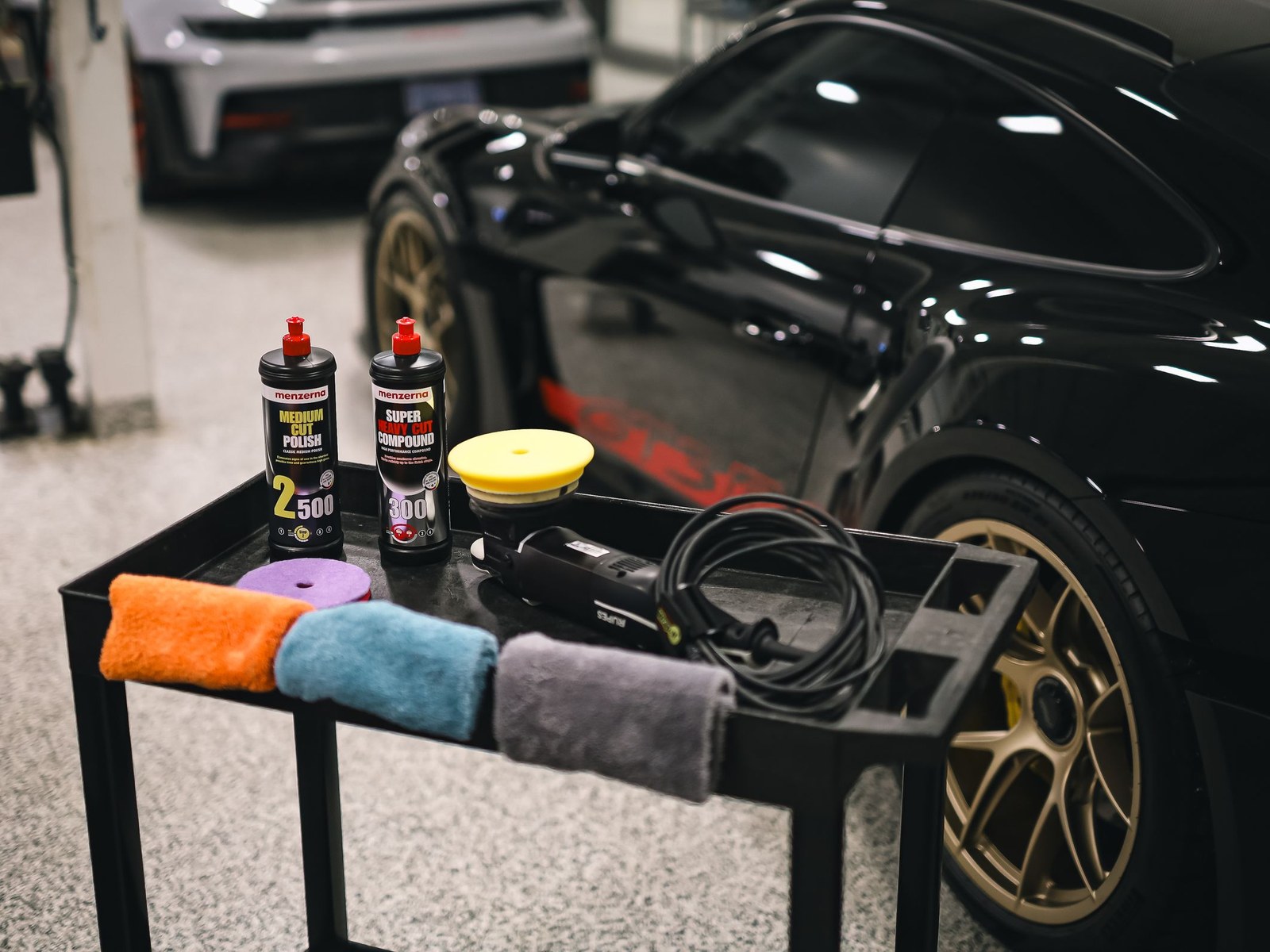 Profesionalios poliravimo priemonės ir įranga prie sportinio automobilio